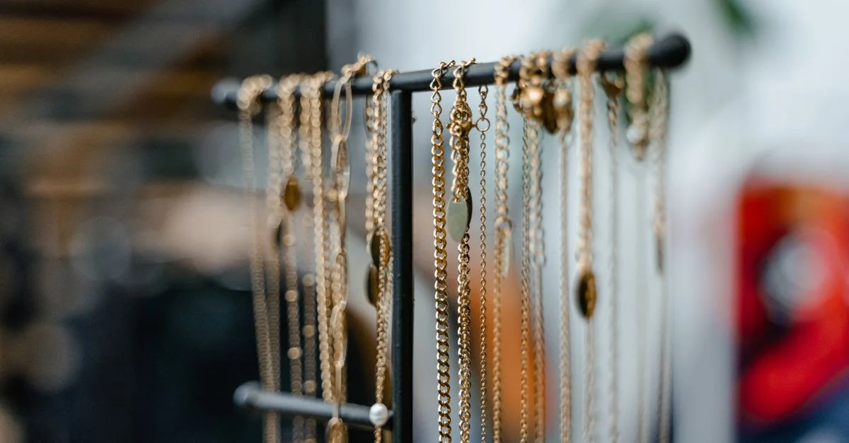 Gros plan de colliers en or exposés sur un porte-jewelry pour une décoration intérieure élégante.