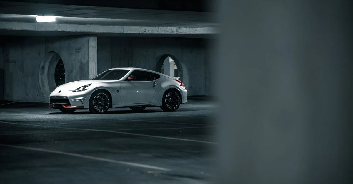 Une voiture coupé blanche luxueuse garée dans un garage moderne et urbain avec une ambiance élégante.