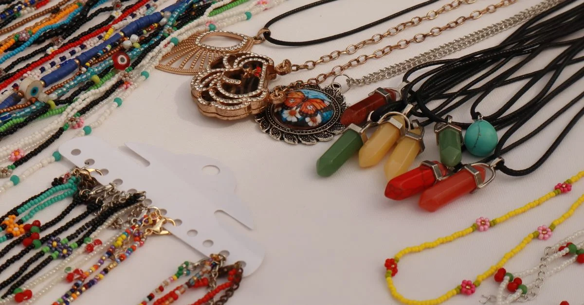 Un large choix de colliers et pendentifs perlés, faits main et aux couleurs éclatantes, est exposé et proposé à la vente.